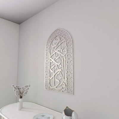 Komplett silberne Mihrab-Metall-Wandkunst Sure Rahman Vers 13 in einer Ecke über einem weißen Tisch