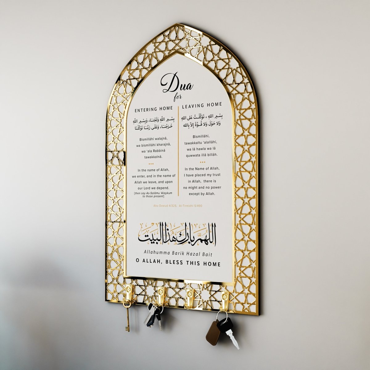 An arched white key holder with a gold geometric border, printed with the duas for entering and leaving the home in Arabic, transliteration and English