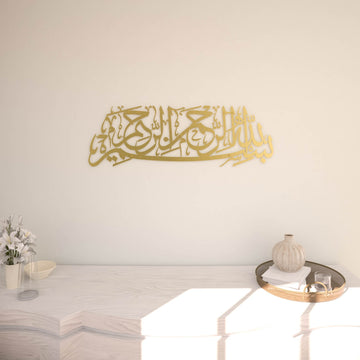 Matte Metall-Wandkunst mit Bismillah in Gold, an einer cremefarbenen Wand über einer weißen Konsole