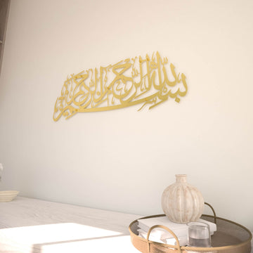Matte Metall-Wandkunst mit Bismillah in Gold, Schrägansicht von rechts an einer cremefarbenen Wand