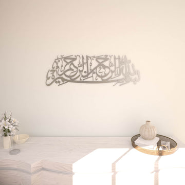 Matte Metall-Wandkunst mit Bismillah in Silber, an einer cremefarbenen Wand über einer weißen Konsole