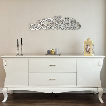 Silver Surah Ar-Rahman 13th verse calligraphy wall art, wide view over a console with curved legs