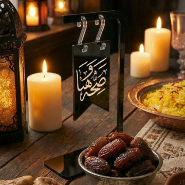 Saha w Hana banner sign on a black acrylic stand at an iftar table