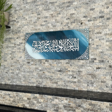 Kalima-Shahada-Wandkunst aus Glas, silbernes Acryl auf blau-weißem Glas, an einer Steinwand