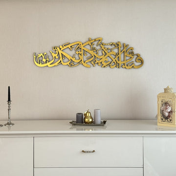 Gold acrylic Surah Ar-Rahman 13th verse calligraphy wall art above a white console