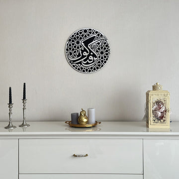 Full Silver Kun Faya Kun round wooden acrylic wall art above a white sideboard