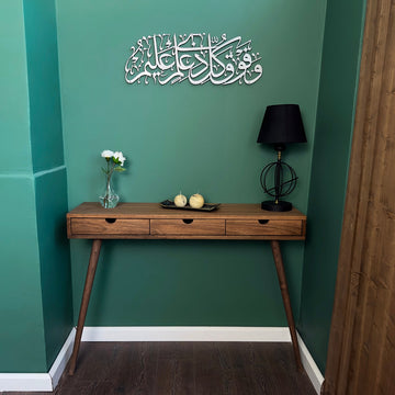 Surah Yusuf Ayat 76 metal wall art in Matte Silver, 69 cm, above a wooden console table