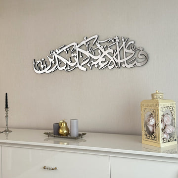 Silver Surah Ar-Rahman 13th verse wall art, right-side view above a console and lantern