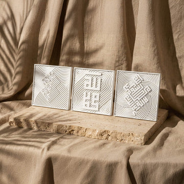 Trois carreaux coufiques en relief de pierre blanche : Fatihah, Allah et Muhammad (paix sur lui), Kalima, sur une dalle