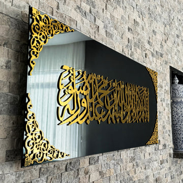 Nahe Schrägansicht der Kalima-Shahada-Kalligraphie in goldenem Acryl auf schwarzem Spiegelglas mit Eckornamenten