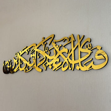 Close-up of the gold acrylic Ar-Rahman 13th verse calligraphy with its black wooden edge