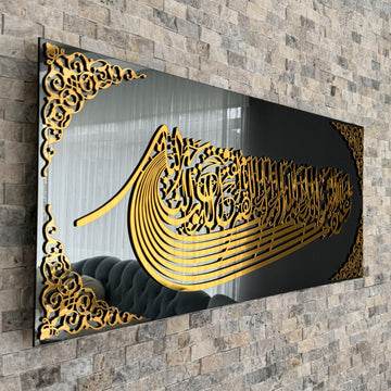 لوحة زجاج مرآة أسود بالاستعاذة والبسملة بخط أكريليك ذهبي على شكل سفينة على جدار حجري، لقطة مائلة مقربة