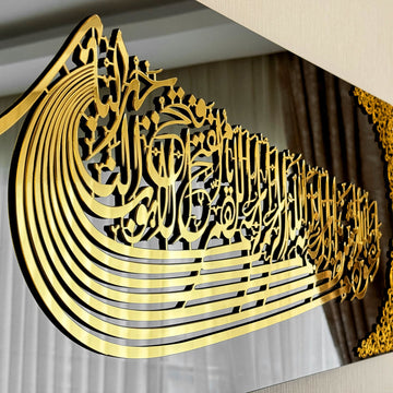 لقطة مقربة لخط الاستعاذة والبسملة الأكريليكي الذهبي على شكل سفينة تُظهر الحروف المتعددة الطبقات