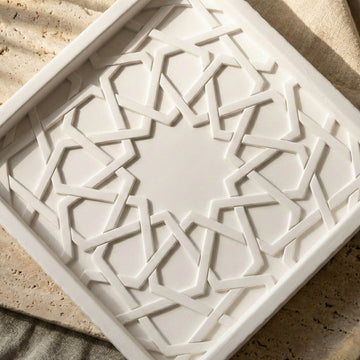 Close-up of the Mexuar geometric star pattern on the white stone relief, turned diagonally