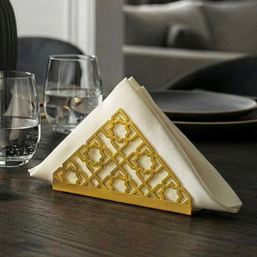Geometric metal napkin holder in gold on a set table