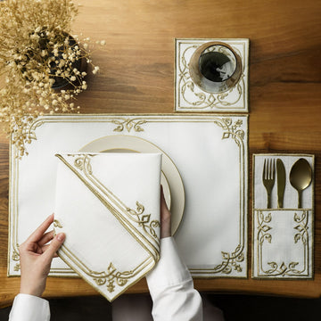 Gold interlocking scroll border placemat with napkin on a plate, coaster and cutlery pouch, overhead view