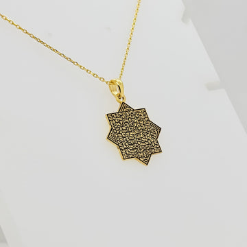 Gold octagonal Ayatul Kursi pendant turned at an angle on a white background