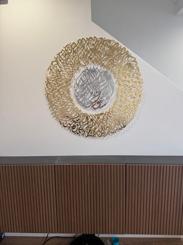 "وصلت هذه القطعة الجميلة قبل الموعد المتوقع. تمامًا في الوقت المناسب قبل جميع حفلات رمضان/الإفطار. كانت معبأة بعناية فائقة. إنها قطعة فنية جمالية تجعل غرفة المعيشة الخاصة بي تبدو أكثر جمالًا. زينت منزلي لرمضان وهذه القطعة هي الإضافة المثالية. الملاحظة الوحيدة هي أن الجزء السفلي لا يبقى قريبًا من الجدار. لست متأكدًا من كيفية تثبيتها على الجدار. بالإضافة إلى ذلك، يمكن جعل البراغي في الأعلى أصغر وأقل وضوحًا. بخلاف ذلك، إنها مثالية ما شاء الله."
