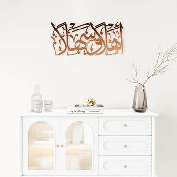 Kupferne Ahlan wa Sahlan Metall-Wandkunst über einem weißen Sideboard, weite Ansicht der ganzen Wand