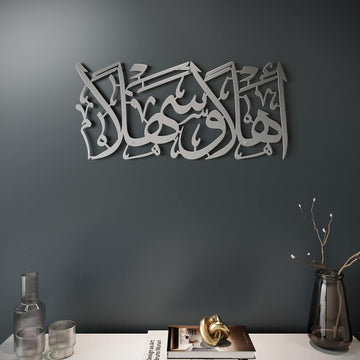 Ahlan wa Sahlan Metall-Wandkunst in Silber, schräge Ansicht an dunkelgrauer Wand