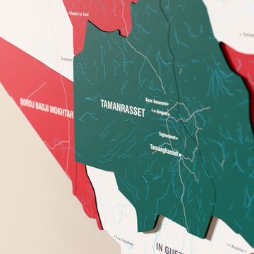 Close-up of the Flag colored Algeria wooden wall map with layered regions and printed names