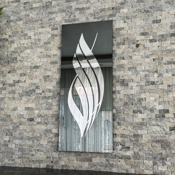 Silver Acrylic Allah calligraphy on black tempered glass, angled view showing the reflective glass