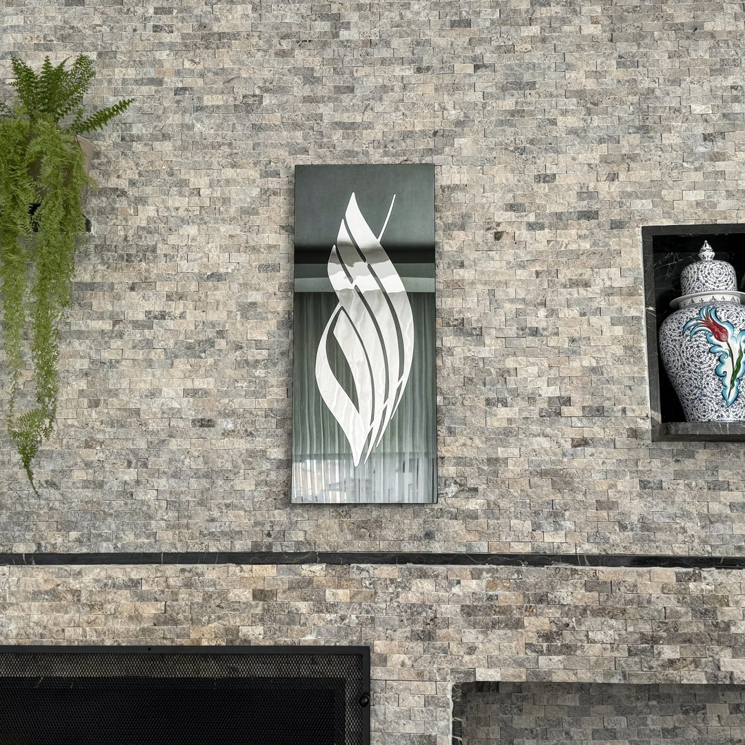 Silver Acrylic Allah calligraphy on black tempered glass beside a stone wall niche with a ceramic jar