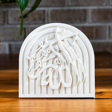 Allah-u Akbar stone relief arch plaque, front view on a wooden table
