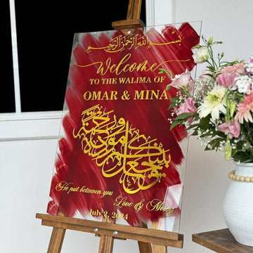 Arabic wedding sign on glass with gold Surah Ar-Rum 30:21 calligraphy over red brush strokes, on an easel