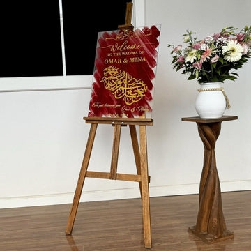 Wedding sign on a wooden easel next to a twisted wooden stand with flowers, wide view