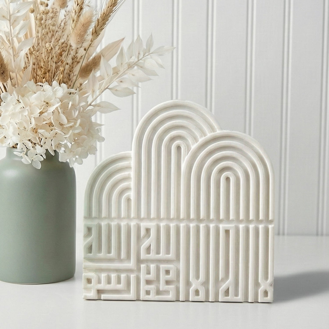 Decorative arch-shaped ceramic piece with a vase of flowers on a light background