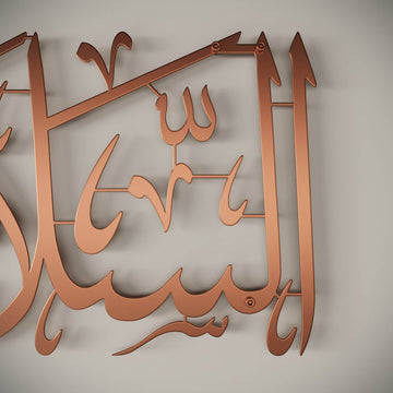 Gros plan de la calligraphie en métal As-Salamu Alaykum cuivré mat, montrant les vis de fixation murale
