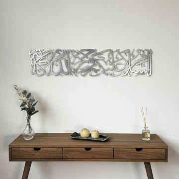 Silver Assalamu Alaikum Wa Rahmatullahi Wa Barakatuh metal wall art above a wooden console