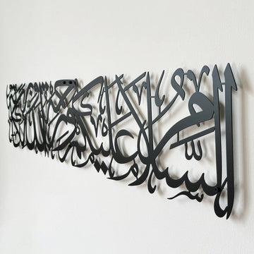 Black metal Assalamu Alaikum wall art calligraphy, close side angle on a white wall