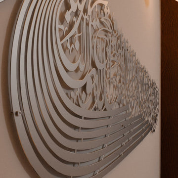 Close angled view of the silver ship-shaped Auzu Basmala metal wall art, showing the layered curved lines