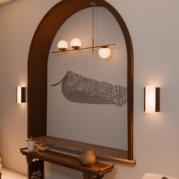 Silver ship-shaped Auzu Basmala metal wall art in the arched niche, closer front view with wall lights