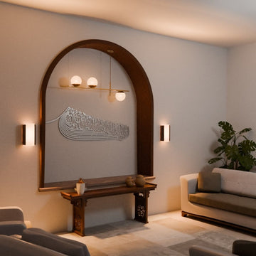 Silver ship-shaped Auzu Basmala metal wall art in an arched niche, angled view with a plant and sofa