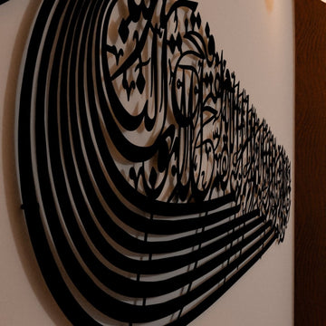 Close angled view of the black ship-shaped Auzu Basmala metal wall art, showing the layered curved lines