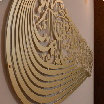 Close angled view of the gold ship-shaped Auzu Basmala metal wall art, showing the layered curved lines