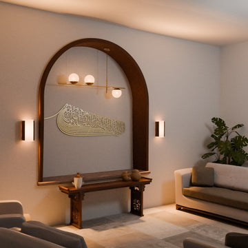 Gold ship-shaped Auzu Basmala metal wall art in an arched niche, angled view with a plant and sofa