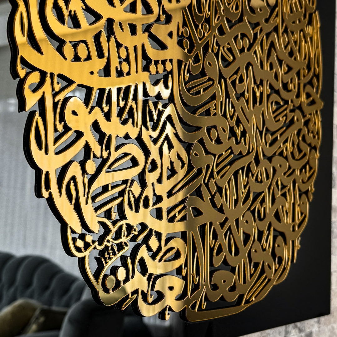 Gros plan de la calligraphie Ayatul Kursi dorée en relief sur verre noir, vue de côté