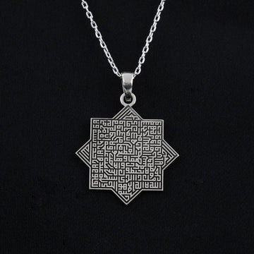 Silver octagonal Ayatul Kursi necklace pendant on a silver chain against black fabric