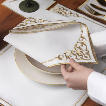 Close-up of gold embroidered napkin corner with Arabic scrollwork on a Basmala dining set