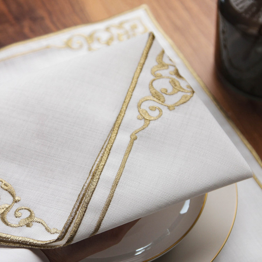Close-up of gold embroidered edge and flourish on a white Basmala dining set napkin