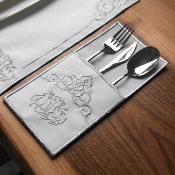 Silver embroidered Basmala cutlery pouch with fork, knife and spoon on a placemat