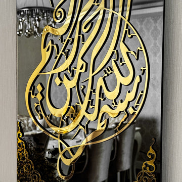 Gros plan de la calligraphie Bismillah dorée sur verre miroir noir reflétant une salle à manger