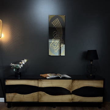 Art mural en verre Bismillah à calligraphie dorée sur un mur sombre au-dessus d'une console en bois et résine