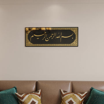 Close front view of the Bismillah Jali Diwani tempered glass wall art with Gold acrylic above a brown leather sofa