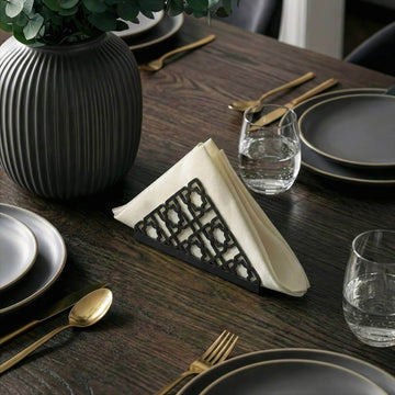 Geometric metal napkin holder in black on a set table