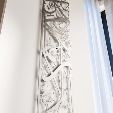 Vertikale Metall-Wandkunst Sure Rahman Vers 13 in Mattsilber, lange Seitenansicht der Schriftsäule neben Vorhang
